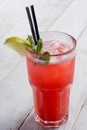 Red Cocktail with ice and lime on white wooden background . Royalty Free Stock Photo