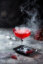 Red cocktail with ice vapor. Cocktail with smoke. Alcohol drink, vodka, ice, party, dry ice.