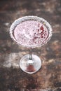 Red cocktail in martini glass with shredded coconut rim, selective focus. Red coconut and strawberry margarita.