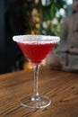 Red cocktail in martini glass with shredded coconut rim, selective focus. Red coconut and strawberry margarita.