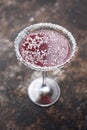 Red cocktail in martini glass with shredded coconut rim, selective focus. Red coconut and strawberry margarita.