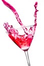 Red cocktail with splashing in the tilted glass