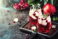 Red cocktail vodka pomegranate juice, with ice and rosemary, bar tools, blue bar counter background, top view