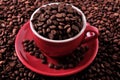 Red coffee cup filled with roasted beans closeup Royalty Free Stock Photo