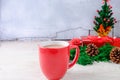 Red Coffee Cup and Red Gift Box with Christmas Tree on White Background Royalty Free Stock Photo