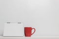 A red coffee mug white note on table over a white background. Royalty Free Stock Photo