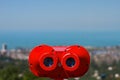 The red coin operated binoculars on the panoramic view of the city Batumi from rooftop platform on the Black Sea with blue sky bac Royalty Free Stock Photo