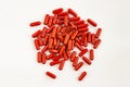 Red capsules pills heap on white background. Medicine pharmacy concept. Close up top view