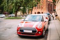 Red Color Car With White Stripes Mini Cooper Parked On Street In Old Part European Town. Royalty Free Stock Photo