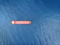 Red color container ship at sea shot from above. Scenic waterscape and lonely boat engaged in export and import business and Royalty Free Stock Photo