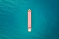 Red color container ship at sea shot from above. Scenic waterscape and lonely boat engaged in export and import business and