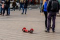 Red color Gyroscooter stands in the middle area among people