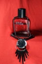 Red color men perfume bottle isolated on red background with female accessories. Perfume bottle of `Wild Stone` with black cap