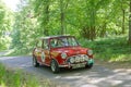 Red color Mini Cooper S classic car from 1964 driving on a country road Royalty Free Stock Photo