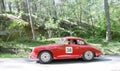 Red color Porche 356 B Karmann Coupe classic car from 1961 driving on a country road Royalty Free Stock Photo