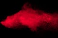 Red color powder explosion on black background.red dust particles splashing. Royalty Free Stock Photo