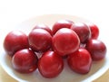 Red Color Ripe Gulf Ruby Plum Fruits Piled up on White Plate