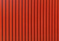 Red color straight line pattern texture. Bright red background with black strips.