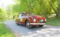 Red color Tatra T600 Tatraplan classic car from 1951 driving on a country road