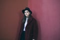 Red color teen girl portrait. Stylish hat and fur coat. serious facial expression. Melancholic mood. Neglect and