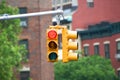 Red color traffic light with buildings in the background.