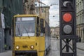 Red color traffic light with old yellow tramway in the background. Royalty Free Stock Photo