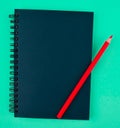 Red color wood pencil crayon placed on top of a blue colored paper diary Royalty Free Stock Photo