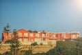 Red colored apartments in Greece with blue sunny sky at the background