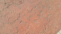 Red colored damaged road or paved pathway with crackes