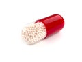 Red colored pill on white background