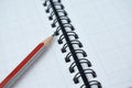 A red colored wood pencil crayon placed on top of a white spiral note book Royalty Free Stock Photo