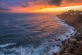 Red colorful sunset and vivid dramatic sky at rocky shore of the Atlantic ocean