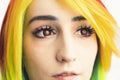 Rainbow-haired girl with red eyes and long dark lashes slowly looking into the camera extreme close-up shot Royalty Free Stock Photo