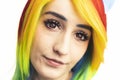 Rainbow-haired girl with red eyes and long dark lashes slowly looking into the camera extreme close-up shot Royalty Free Stock Photo