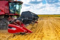 A red combine harvester with a mower in a field