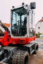Red compact wheeled excavator parked at site. Royalty Free Stock Photo