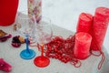 Red composition of the winter outdoor dinner consisting of red candles, beads, red and blue wine glasses covered with