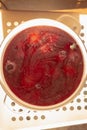 Red compote with mold in a saucepan, background with streaks and bubbles Royalty Free Stock Photo