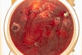 Red compote with mold in a saucepan, background with streaks and bubbles Royalty Free Stock Photo
