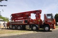 A red concrete pumping truck arriving on site.