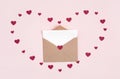 Red confetti hearts and a blank card with an envelope on a pink background. Valentine`s day greeting card. Flat lay, copy space Royalty Free Stock Photo