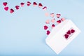 Red confetti hearts fly out of a white envelope on a light blue background. Valentine`s Day. love concept Gift, message for lover Royalty Free Stock Photo