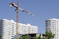 Red construction crane on a background of white buildings and blue sky Royalty Free Stock Photo