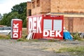 Red containers and mobile toilet of DEK Stavebniny company which provides materials and tools for construction business