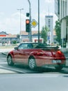 Red convertible car driving in city with VW beetle sign Royalty Free Stock Photo