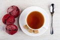 Red cookies, cup of tea, sugar on saucer, teaspoon on table. Top view Royalty Free Stock Photo