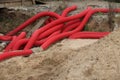 Red corrugated synthetic pipes in a trench Royalty Free Stock Photo
