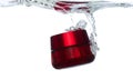 Red Cosmetic container fall into clear water with air bubble. Cosmetic treatment container drop to clear water of freshness. White