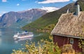 Red cottage against cruise ship in fjord, Flam, Norway Royalty Free Stock Photo