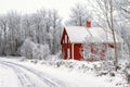 Red cottage by an icy road in a wintry forest landscape Royalty Free Stock Photo